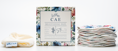 Open CAE box showing washable bamboo breast pads stacked beside it
