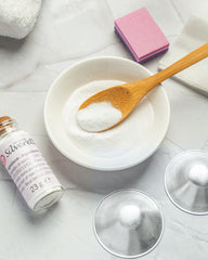 Silverette Cleaning Set with baking soda in a bowl, wooden spoon, sponge, cotton gauze and two silver nursing cups