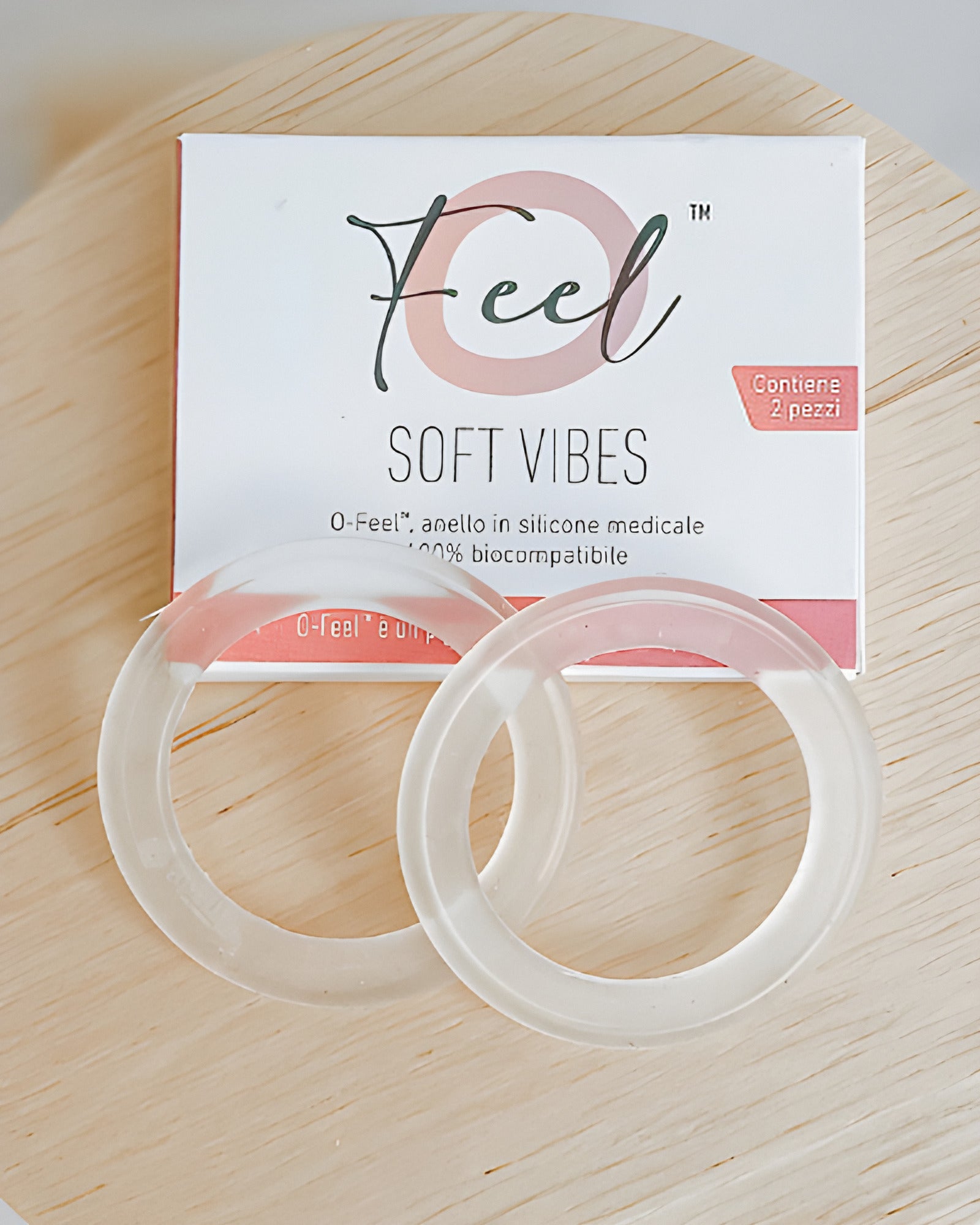Silverette O-Feel Soft Vibes box and two clear silicone rings on a round wooden board